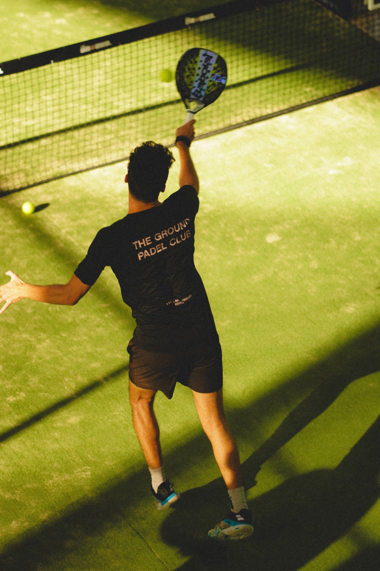 Padel player mid-smash on court
